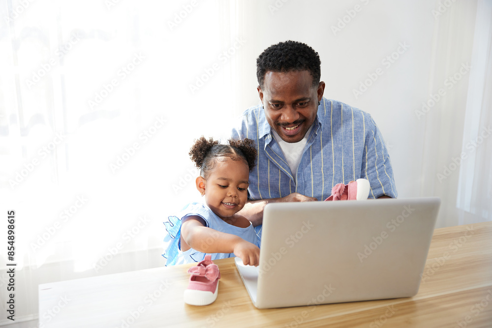 Father doing online shopping and buying more shoes with daughter from laptop computer Father doing online shopping and buying more shoes with daughter from laptop computer