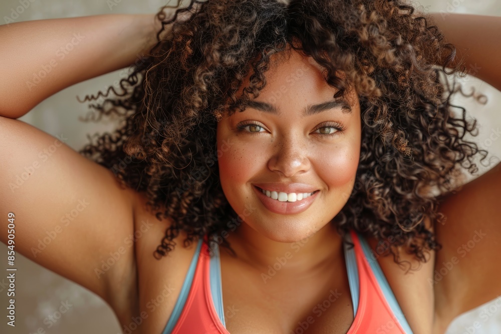 happy plus size african american woman in red tank top and blue leggings doing dance moves, with her hands on her head and arms at her sides, in a front view, against beige background, happy plus size african american woman in red tank top and blue leggings doing dance moves, with her hands on her head and arms at her sides, in a front view, against beige background,