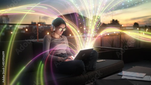 Woman working on laptop at rooftop in the evening with colorful light streams around her. Visualization of the Internet by information lines flying to the global digital network