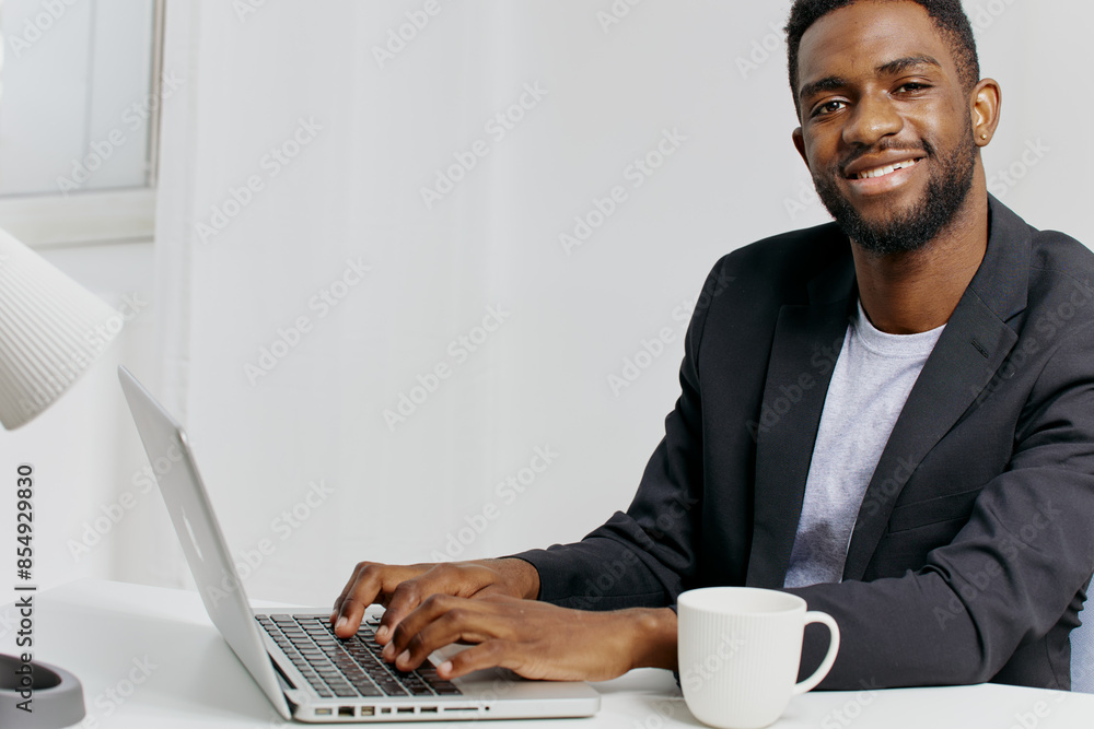 African american businessman working on laptop at desk in modern office environment African american businessman working on laptop at desk in modern office environment