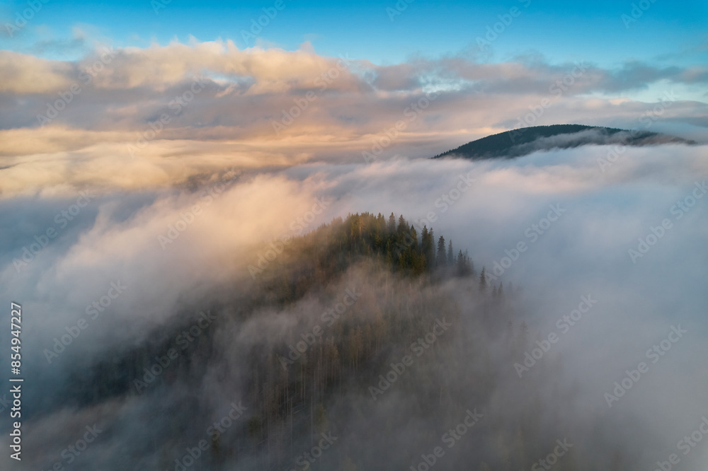 Fog spreads over the mountains at dawn. The sun rises on the horizon. Carpathians in the morning. Aerial drone view. Fog spreads over the mountains at dawn. The sun rises on the horizon. Carpathians in the morning. Aerial drone view.