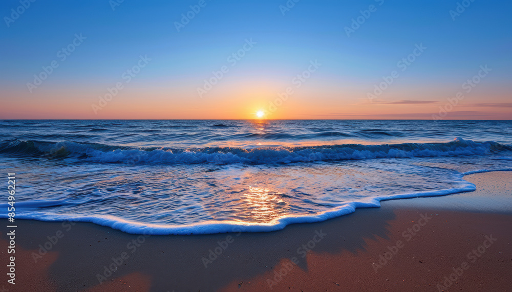 Obraz premium The ocean is calm and the sun is setting, creating a beautiful