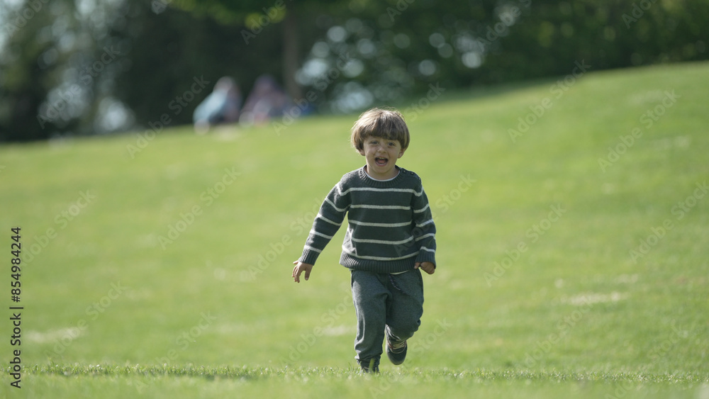 Joyful Boy Running Freely in Lush Green Park on a Bright Sunny Day Joyful Boy Running Freely in Lush Green Park on a Bright Sunny Day