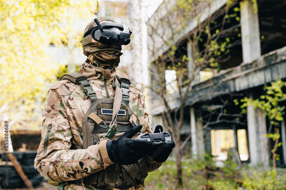 Fototapeta premium UAV Army operator in FPV glasses controls drone with bomb to drop to enemy. Concept modern war with technology airplane robots