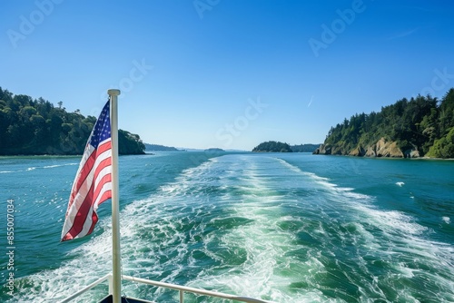 On a sunny blue sky day in the San Juan Islands, a American flag flies off the back of a boat.