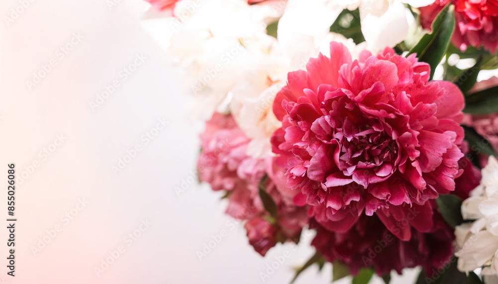 Beautiful peonies of different colors in a glass vase on the windowsill. Beautiful peonies of different colors in a glass vase on the windowsill.