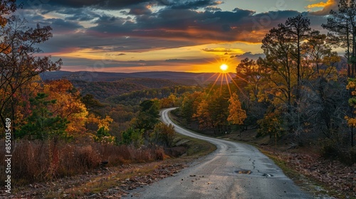 Colorful sunset over winding road through scenic forest 