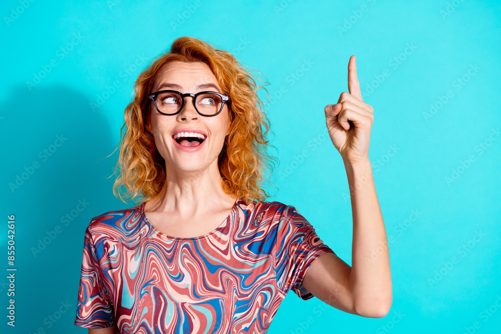Portrait of nice lady look direct finger up empty space wear t-shirt isolated on teal color background Portrait of nice lady look direct finger up empty space wear t-shirt isolated on teal color background