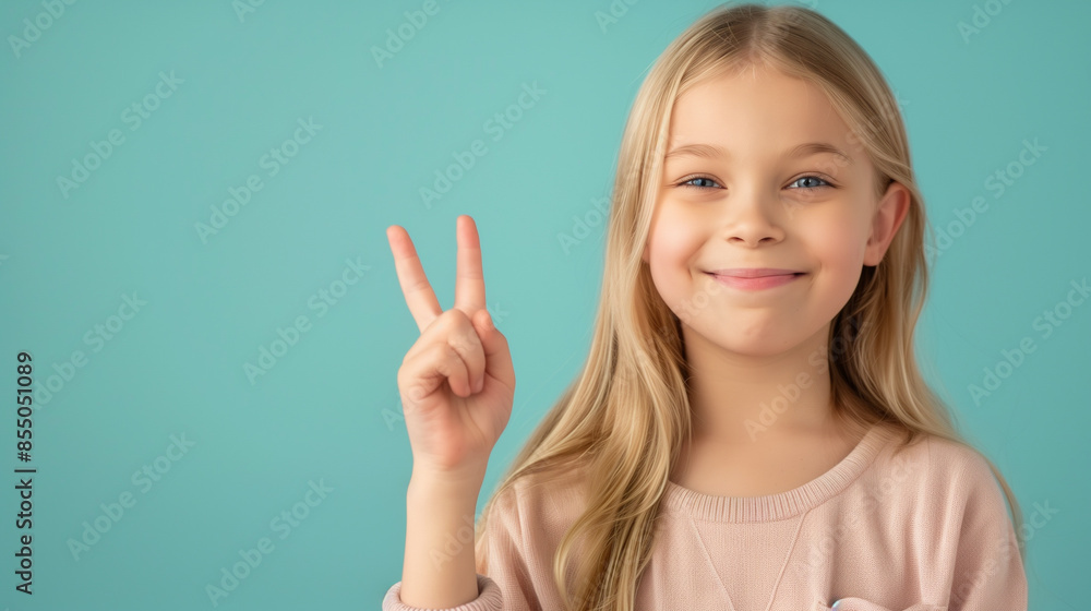 Smiling girl with peace gesture on blue background Smiling girl with peace gesture on blue background