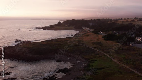 Descending close-up aerial shot of the nature boardwalk trail at Moonstone Beach during sunset in Cambria, California. 4K photo