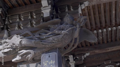 Near the ceilings of Buddhist temples in Japan there are pieces of wood where semi-angelic women of Buddhism are carved. photo