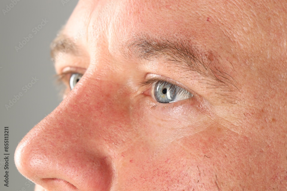 Man with beautiful blue eyes on light grey background, closeup Man with beautiful blue eyes on light grey background, closeup