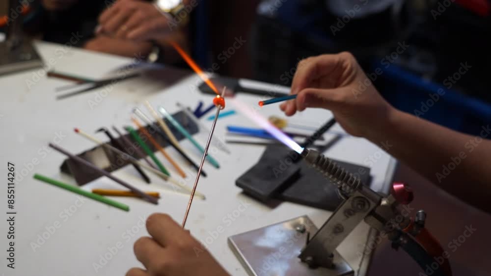creating a glass jewel with a blowtorch in an artisanal glass workshop creating a glass jewel with a blowtorch in an artisanal glass workshop