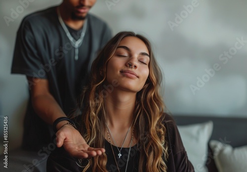 Man Meditating With Eyes Closed While Woman Sits Beside Him on a Couch