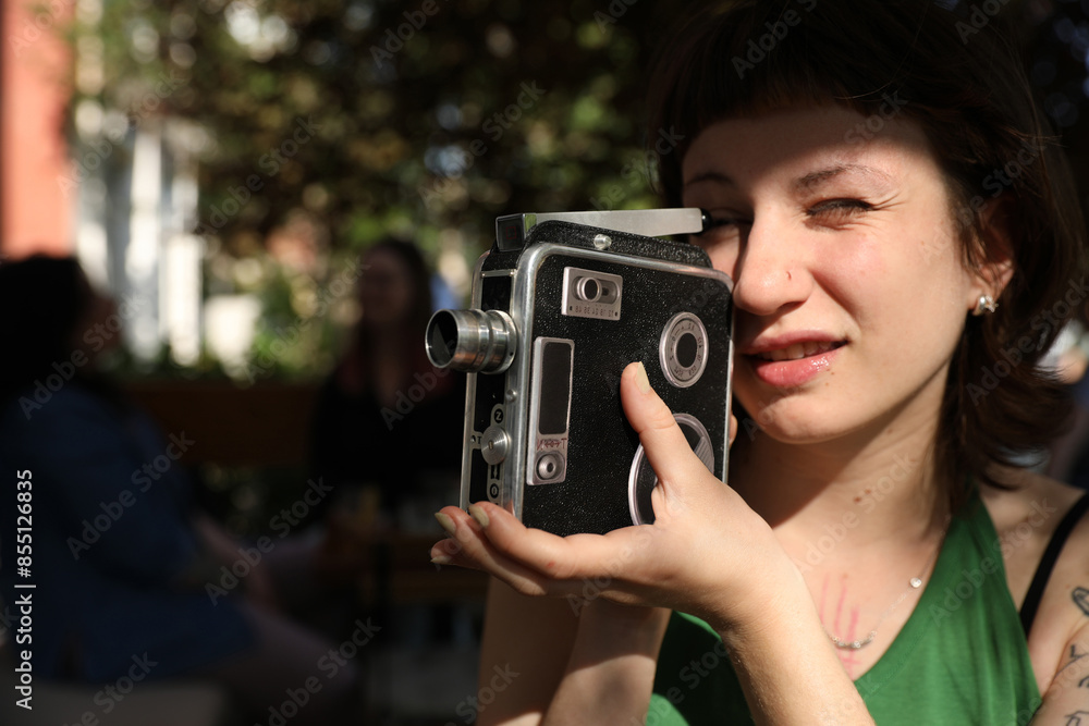 young woman holding retro camera in a park young woman holding retro camera in a park