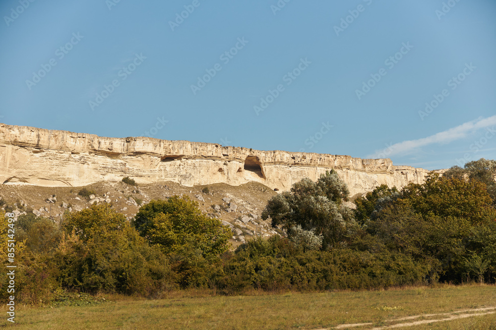 Fototapeta premium Scenic cliff landscape with trees and road in background perfect for travel destination advertisement
