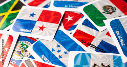 Billede på lærred High angle view of different central america country flag stickers on table
