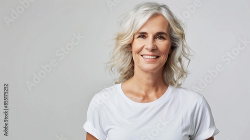 smiling middleaged woman in white tshirt blank space for logo or text clothing mockup studio photography © Bijac