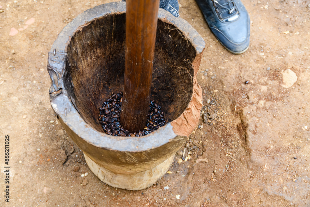 Grinding coffee in a mortar in Chagga tribe Grinding coffee in a mortar in Chagga tribe