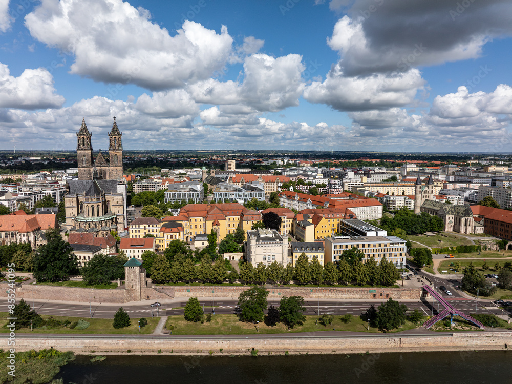 Obraz premium Telephoto photo of Magdeburg. Aerial view of the city center of the state capital. Travel destination in Saxony-Anhalt. Beautiful cloud formations over the city. Sunny day in the city on river Elbe.