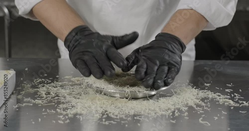 Traditional Turkish dessert kunefe or kunafa. Pastry chef puts kataifi dough in the copper plate with hands. Arabic sweets. Middle eastern national food desserts photo