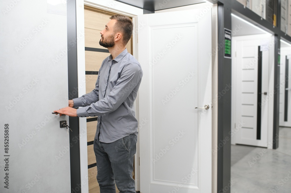 A man chooses a door for the house. Buying a door at a hardware store A man chooses a door for the house. Buying a door at a hardware store