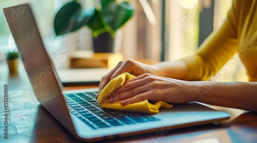 Hygiene, laptop, and closeup of man washing screen to prevent desk dust, filth, and germs. Technology, health, and men clean their computers at home with a cloth. photo