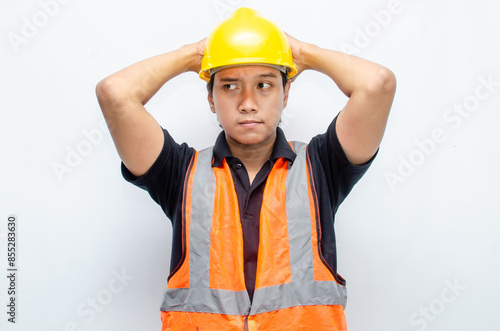 Asian male construction worker in hardhat and orange vest looks sad with crying gesture. stressed overworked concept. workers' insurance concept.