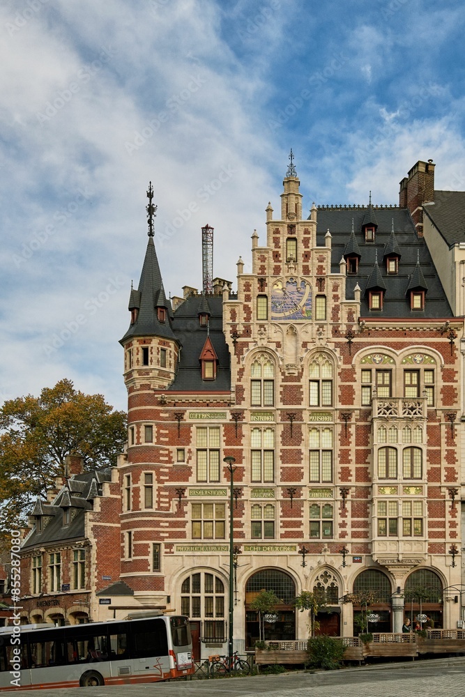 Obraz premium Historic building with intricate architecture and a clear blue sky in Leuven, Belgium.