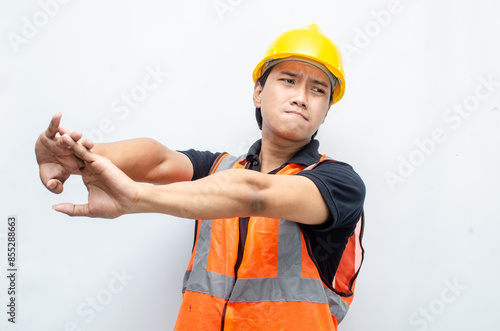 overworked concept illustrated by a sleepy construction worker yawning with hand gestures covering his mouth and stretching his arm. 