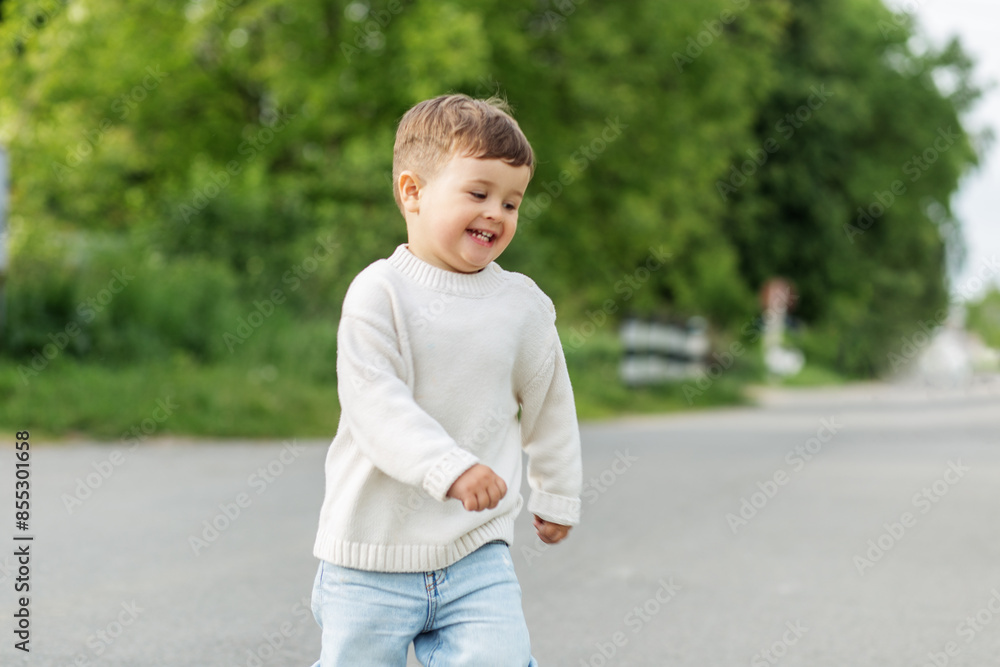 Smiling toddler running outdoors on pathway