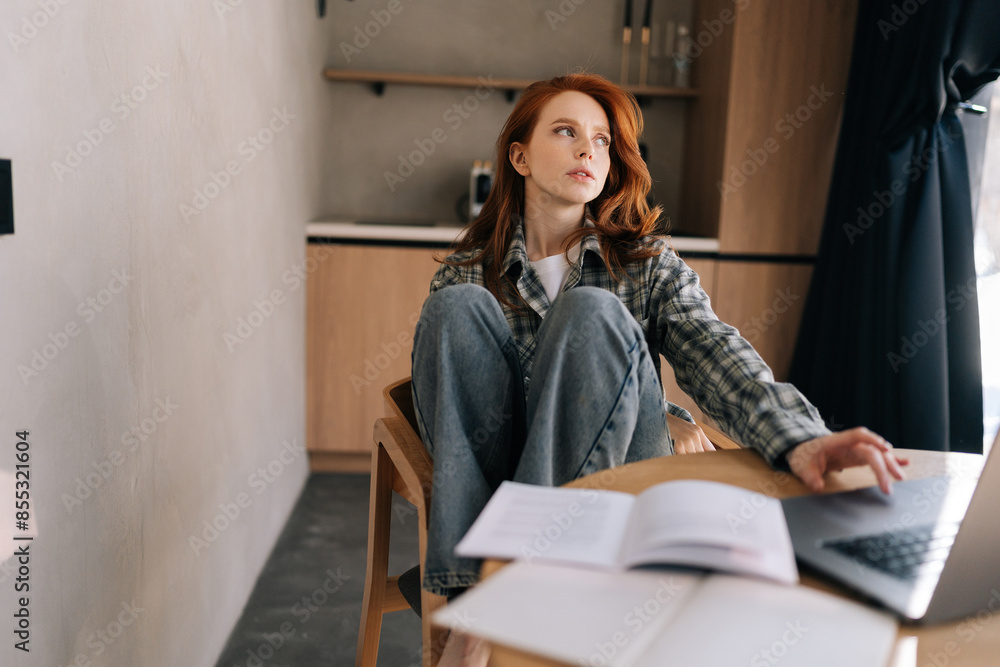 Portrait of pensive young woman working or learning online on laptop looking away thinking of solution sitting at home desk using computer, planning project, considering new ideas, remote work. Portrait of pensive young woman working or learning online on laptop looking away thinking of solution sitting at home desk using computer, planning project, considering new ideas, remote work.