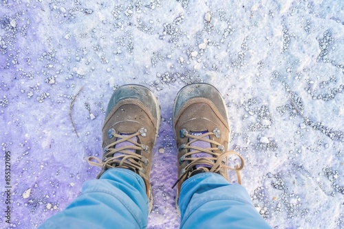 close up of feet in winter shoes on a background of snow and ice. hiking. tracking. Winter. Cold.
