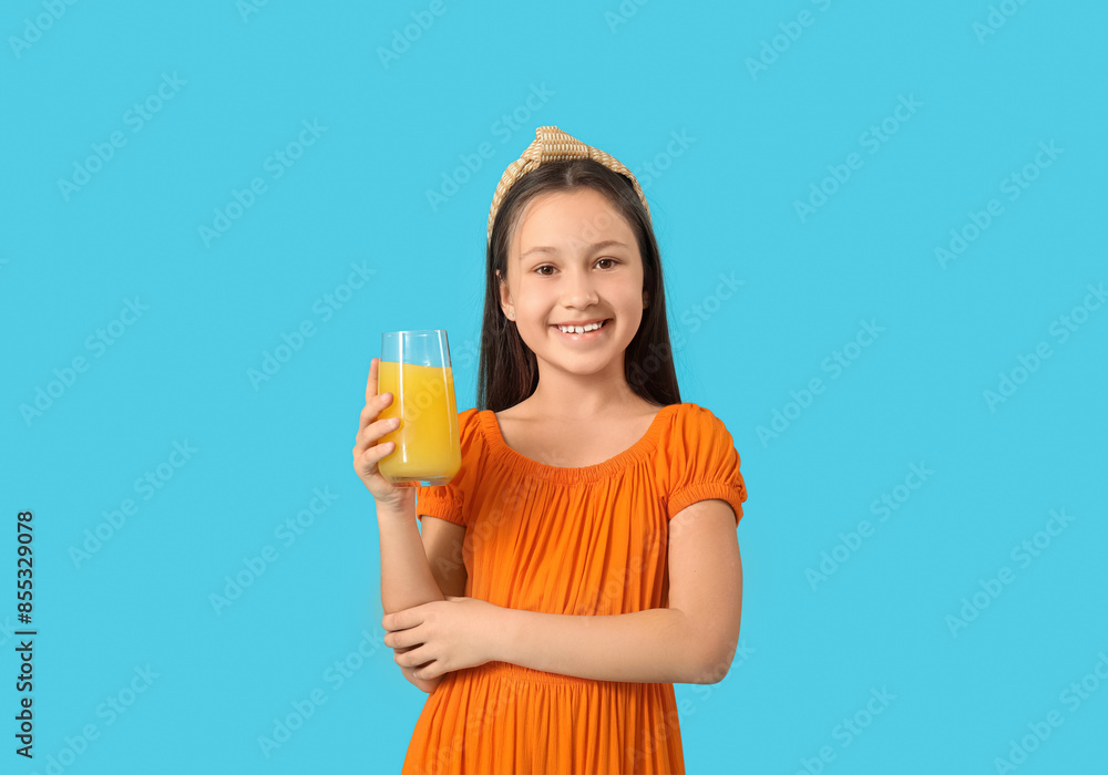 Cute little girl with glass of orange juice on blue background Cute little girl with glass of orange juice on blue background