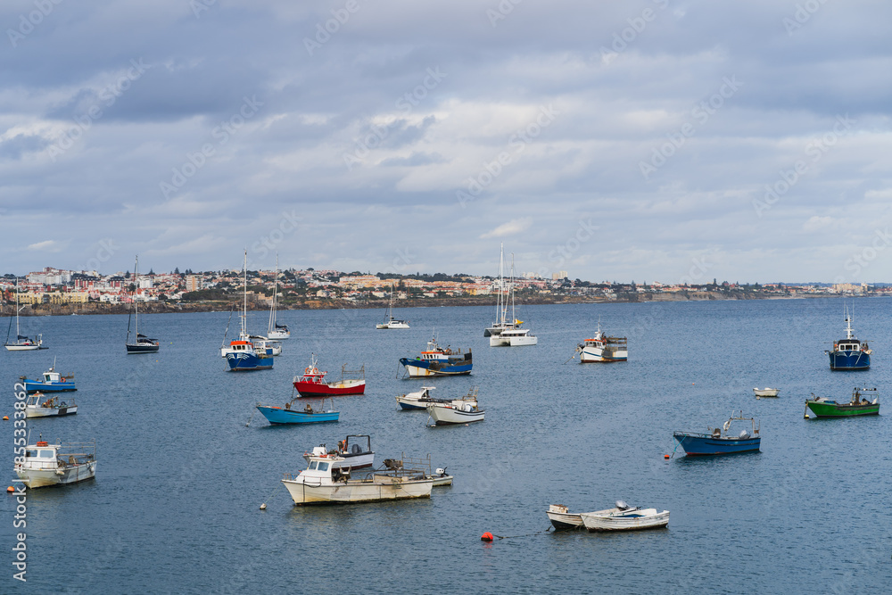 Fishing boats stand near the shore in Cascais Portugal on an evening summer day. Fishing boats stand near the shore in Cascais Portugal on an evening summer day.