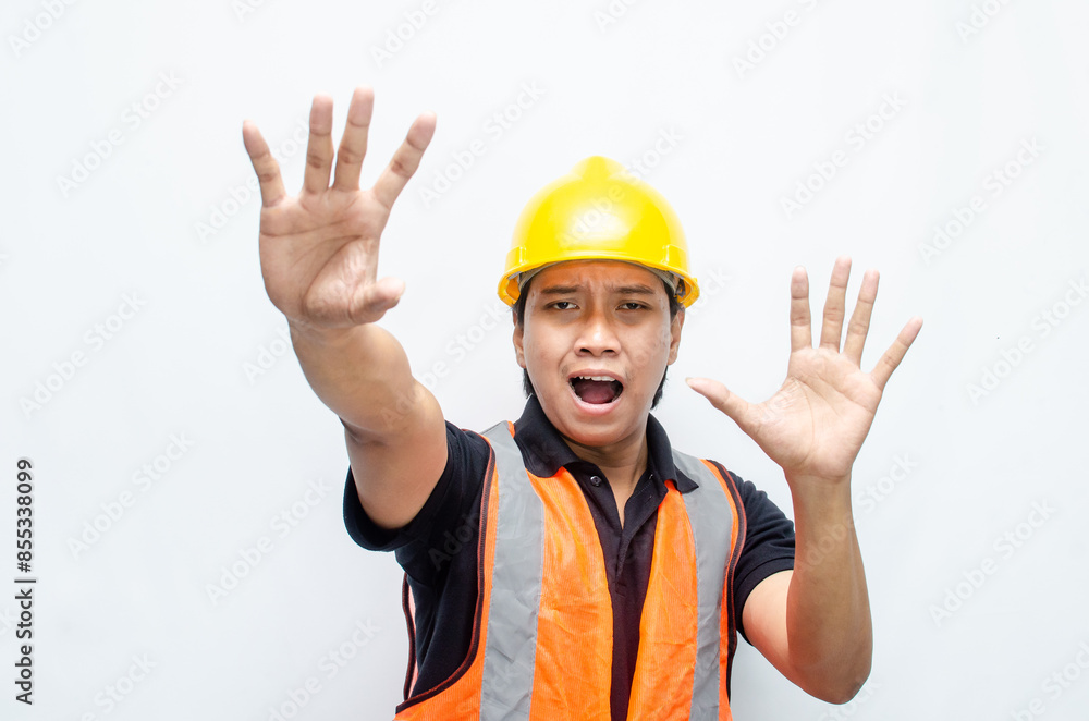 Asian male construction workers in yelow hardhat and orange vest looks frightened and terrified. workplace safety concept