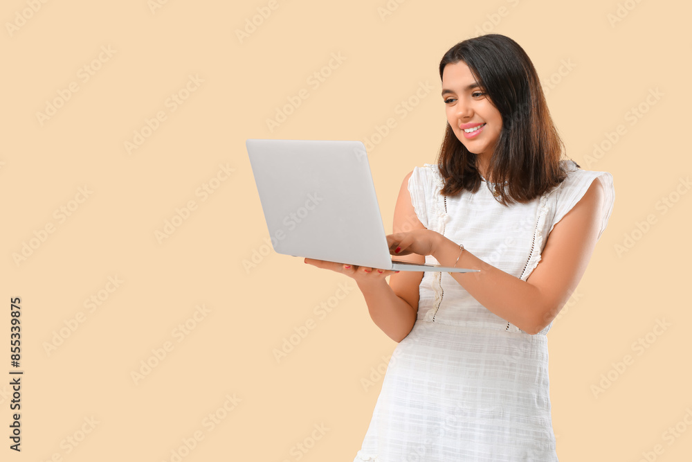 Young woman using laptop on beige background. Online dating concept Young woman using laptop on beige background. Online dating concept