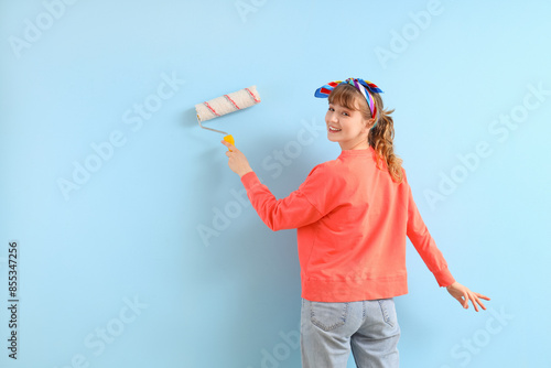 Young woman with paint roll...