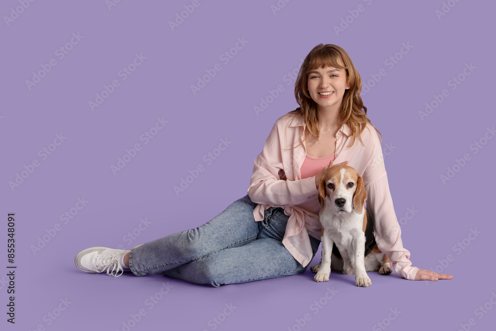 Young woman with cute beagle dog on lilac background Young woman with cute beagle dog on lilac background