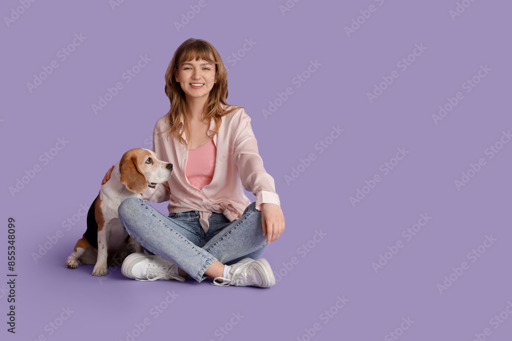 Young woman with cute beagle dog on lilac background Young woman with cute beagle dog on lilac background