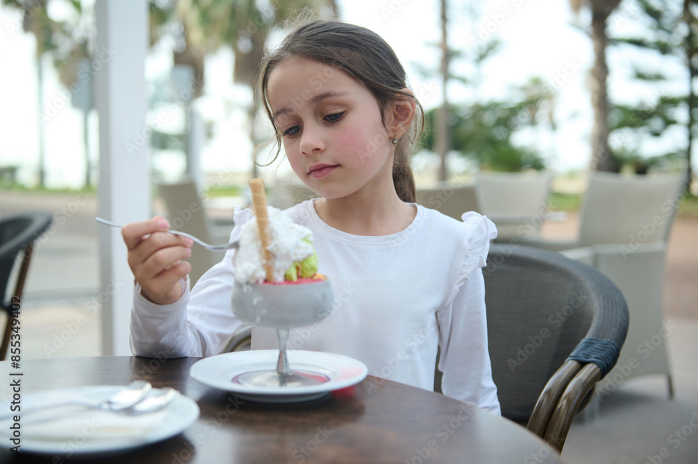 Young girl enjoying dessert at outdoor cafe Young girl enjoying dessert at outdoor cafe