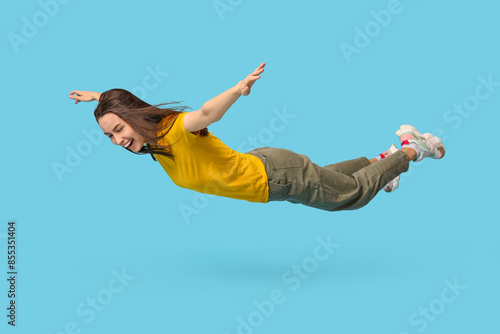 Joyful young woman flying o...