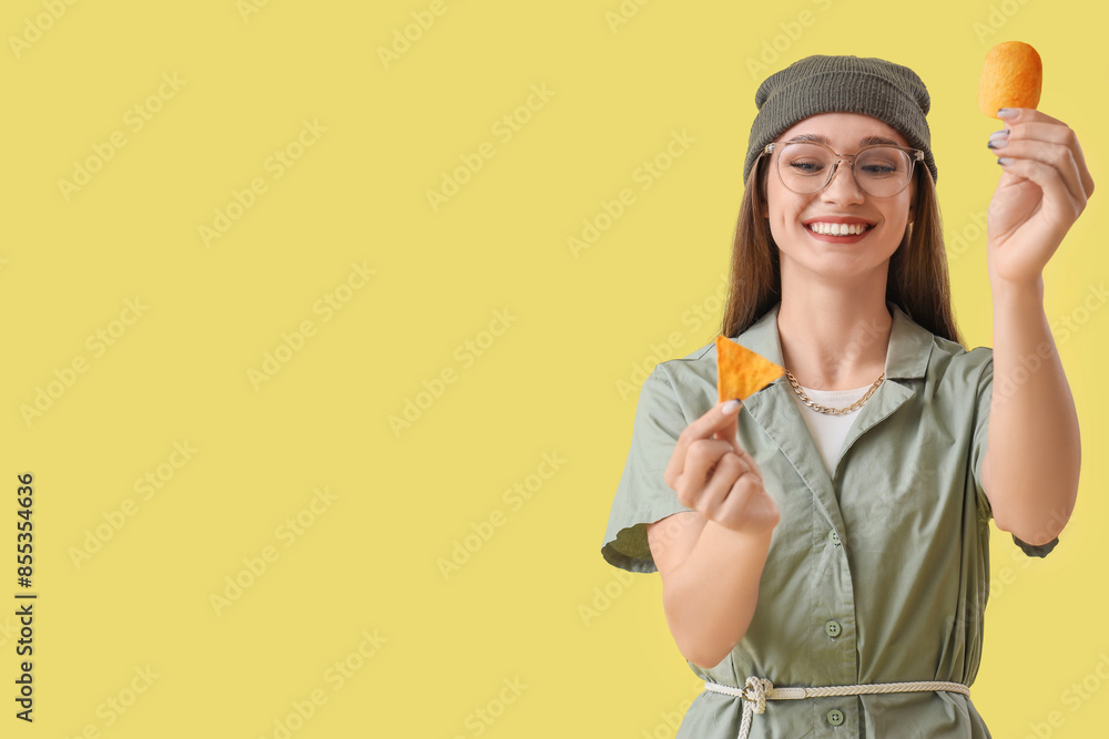 Young woman with chips on yellow background Young woman with chips on yellow background