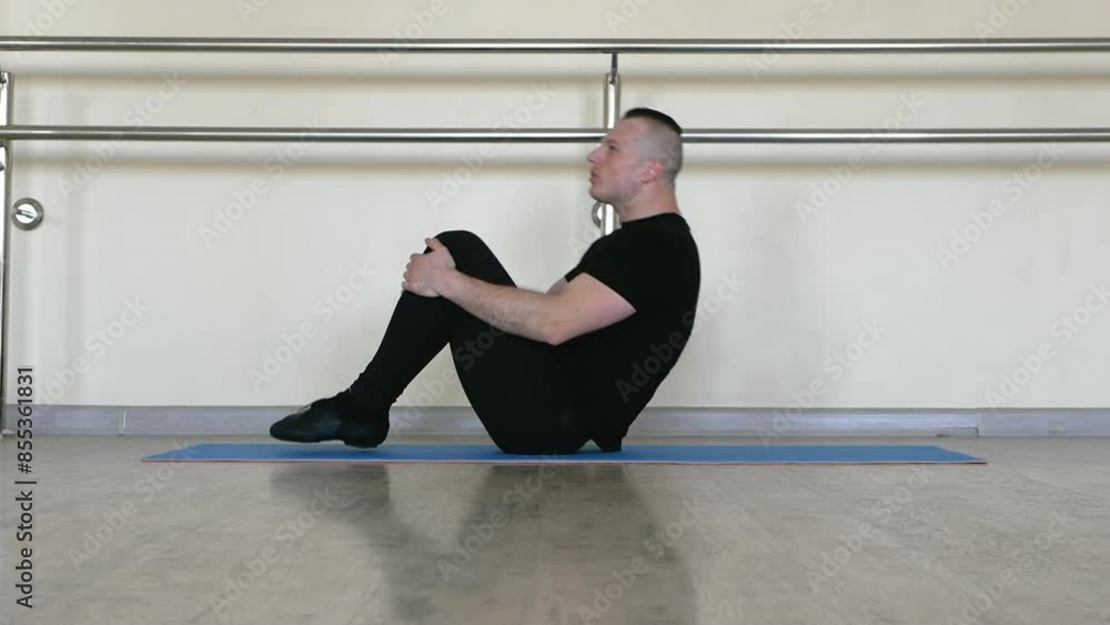 Warm-up dance gymnastics on the mat, warming up the dancer in the fitness room. Sports dancer doing stretching. Warm-up dance gymnastics on the mat, warming up the dancer in the fitness room. Sports dancer doing stretching.