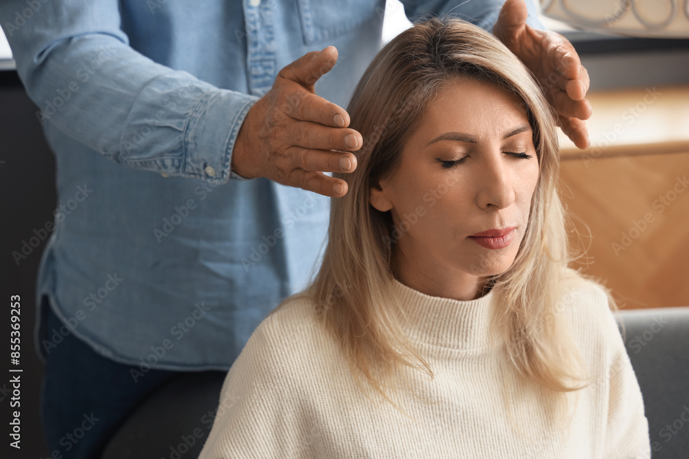 Fototapeta premium Male psychologist hypnotizing woman in office, closeup