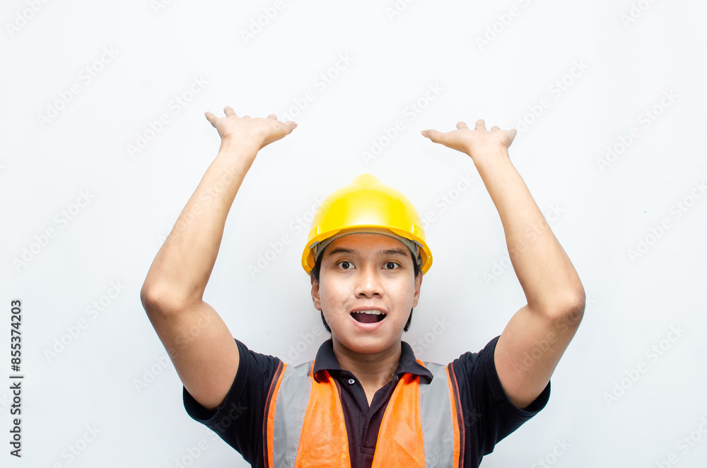 A happy, surprised asian construction worker in black shirt and yellow safety helmet pointing a finger and presenting something ads.
A happy, surprised asian construction worker in black shirt and yellow safety helmet pointing a finger and presenting something ads.