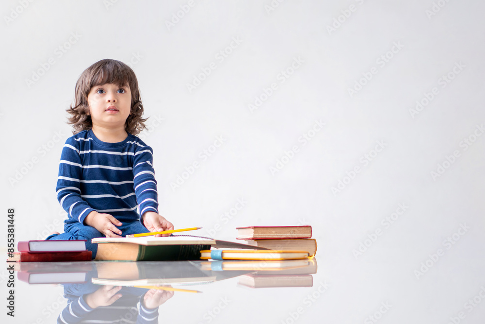 Education and back to school concept. Portrait of Happy little kindergarten child boy learning to read a book on the floor. Preschool children kids enjoy and fun study and doing homework at home. Education and back to school concept. Portrait of Happy little kindergarten child boy learning to read a book on the floor. Preschool children kids enjoy and fun study and doing homework at home.