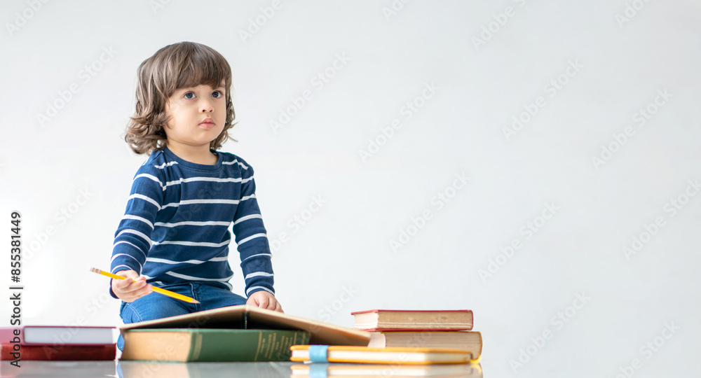 Education and back to school concept. Portrait of Happy little kindergarten child boy learning to read a book on the floor. Preschool children kids enjoy and fun study and doing homework at home. Education and back to school concept. Portrait of Happy little kindergarten child boy learning to read a book on the floor. Preschool children kids enjoy and fun study and doing homework at home.