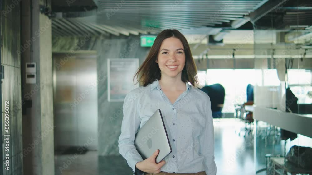 As a symbol of success and motivation, a confident businesswoman is seen walking through a modern, stylish office with a laptop, creating a perfect work environment for professionals As a symbol of success and motivation, a confident businesswoman is seen walking through a modern, stylish office with a laptop, creating a perfect work environment for professionals