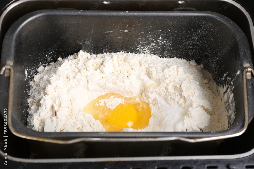 Making dough. Flour and egg in breadmaker pan, closeup Making dough. Flour and egg in breadmaker pan, closeup